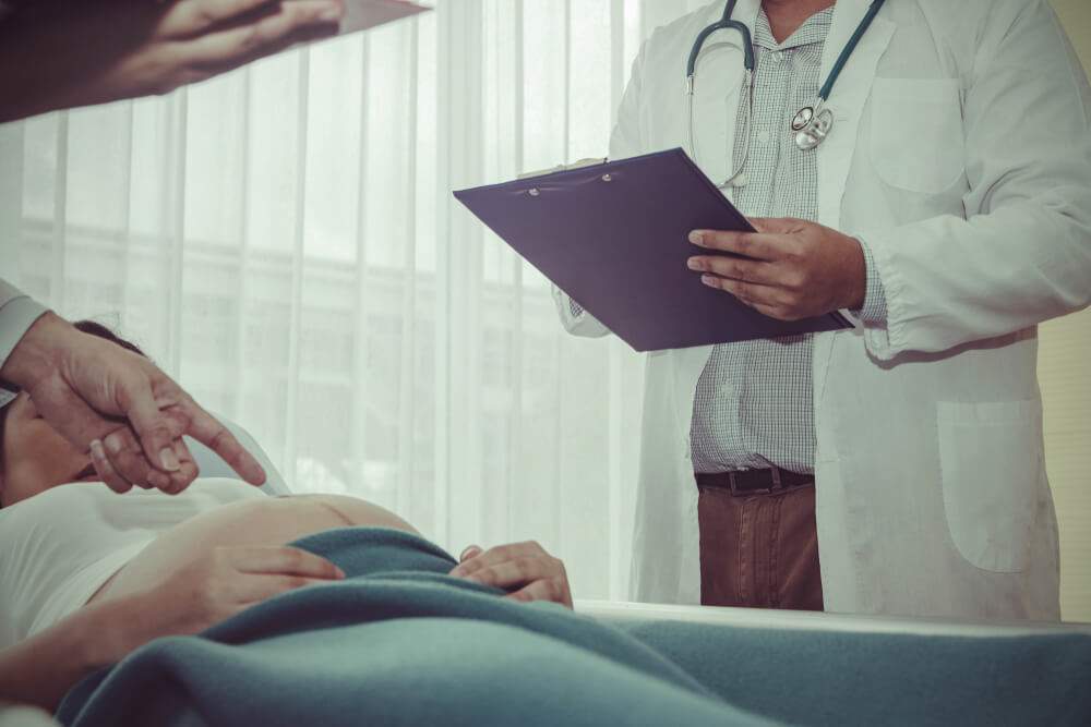 A doctor is examining a woman who has had a C-delivery