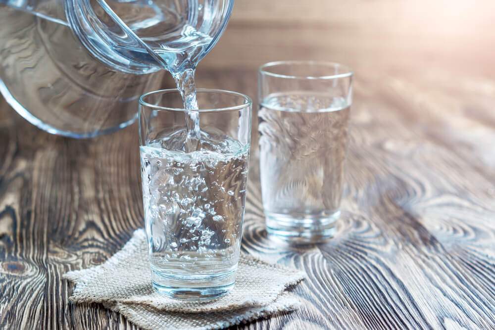 Two glasses of magnetic water on a wood table